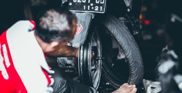 mechanic changing the motorbike's tires