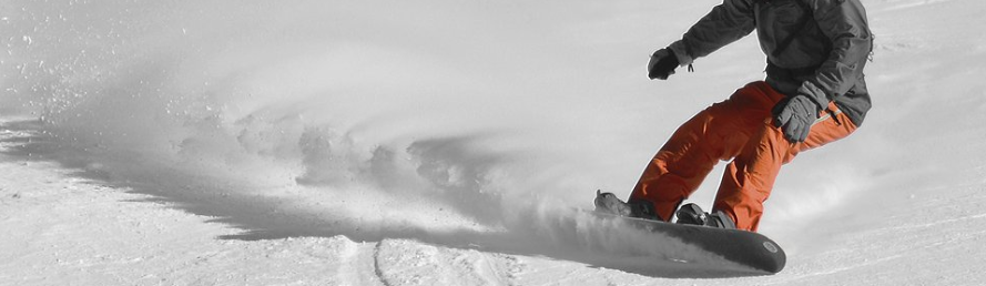 snowboarder turning hard on a downward slope