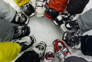 snowboarders showing their boots in a circle