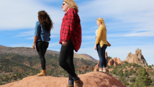 Three women standing over the hill