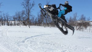 Man doing snowmobile stunt