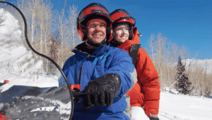 Couple Sitting on Snowmobile