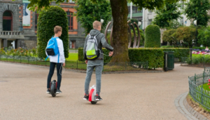 Two boys riding on a hoverboard