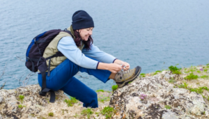 girl ties the laces on hiking boots